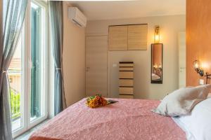 a bedroom with a pink bed and a window at Grecale in Loano