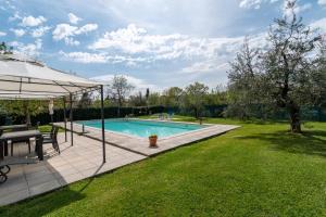 a swimming pool with a table and an umbrella at Mugellese in Civitella in Val di Chiana