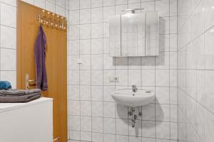une salle de bain blanche avec un lavabo et un miroir dans l'établissement Schöne 2-Raum-wohnung im Zentrum, à Waltershausen 20 autres photos