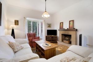ein Wohnzimmer mit 2 weißen Sofas und einem Kamin in der Unterkunft Chalet con piscina en la Barrosa in Chiclana de la Frontera
