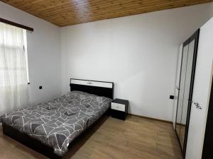 a bedroom with a bed in a white room at Barn House Guba in Qǝçrǝş