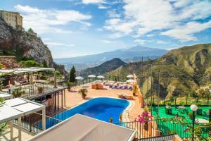 ein Resort mit Pool und Bergen im Hintergrund in der Unterkunft Garden Cottage I Dammusi - Limoni in Castelmola