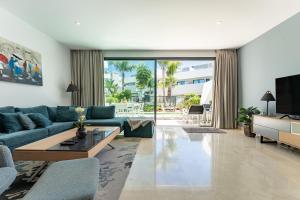 a living room with a blue couch and a tv at La Valvega de La Cala lift indoor in Mijas
