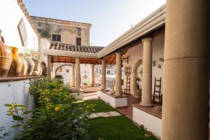 Una vista exterior de una casa con columnas y un patio. en Appartamento Don Camillo, en Riposto