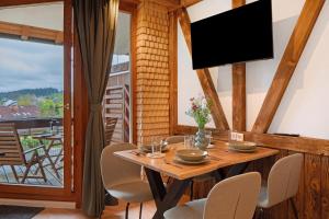 a dining room with a table and chairs and a tv at Ferienwohnung Am Bärenhof in Titisee-Neustadt