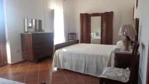 a bedroom with a bed and a dresser and a mirror at da Ciccio e Concy in Tursi