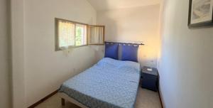 a small bedroom with a blue bed and a window at Maison individuelle -800 m de la plage - 6HOURT31 in Le Barcarès