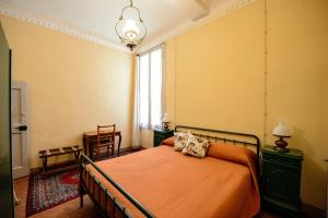 a bedroom with a bed with an orange bedspread and a window at Rinascimento Suite Centro Storico Modena in Modena