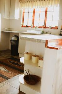 eine Küche mit einer Holzschüssel auf einem Regal in der Unterkunft Cicada Cottage Peaceful Drakensberg Retreat in Underberg