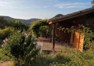 DarbresにあるChalet Jaune - Piscine Partagéeの木製デッキと花が備わる小さなキャビン
