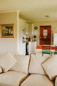 ein Wohnzimmer mit Couch und Küche in der Unterkunft Cicada Cottage Peaceful Drakensberg Retreat in Underberg