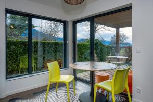 a room with windows and a table and chairs at Appart bureau in Le Touvet