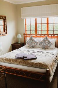ein Schlafzimmer mit einem großen Bett mit Fenster in der Unterkunft Cicada Cottage Peaceful Drakensberg Retreat in Underberg