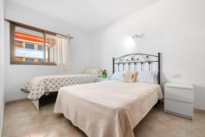 a bedroom with two beds and a window at Apartamento Familiar en la Pineda in La Pineda