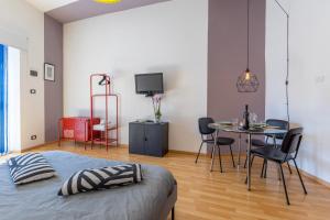 a bedroom with a bed and a table and chairs at La Stanza Modicana - Il Tuo Rifugio in Modica