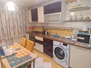 a kitchen with a washing machine and a table at Apartament Superb in Onești