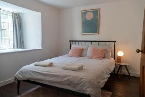 a bedroom with a bed with two pillows on it at Mor Ki -A perfectly situated modern flat in Looe in Looe