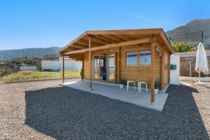 a small wooden cabin with two chairs in front of it at Alojamientos B y J in Arafo