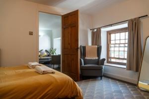 a bedroom with a bed and a chair and a window at Mor Ki -A perfectly situated modern flat in Looe in Looe +12 photos
