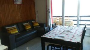 a living room with a table and a couch at Côté Montagne in Orcières