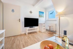 a living room with a flat screen tv and a table at Ferienwohnung Stella Maris in Carrenzien