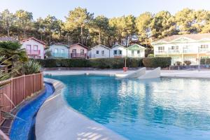 a swimming pool in a residential neighborhood with houses at Maison avec vue, idéale familles in Lacanau-Océan