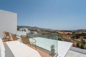 a glass balcony with a table and chairs on it at Villa Anastasio in Kampos Paros