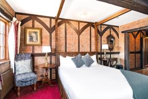 a bedroom with a bed and a chair at The Honest Lawyer, an Ascend Collection Hotel in Nelson