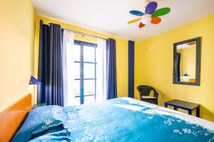 a bedroom with a blue bed with a window at Nautilus 7 in Puerto Naos