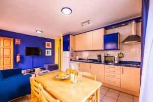 a kitchen with a wooden table and a blue couch at Nautilus 7 in Puerto Naos