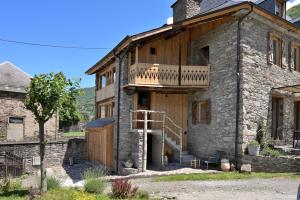 ein altes Steinhaus mit Balkon darauf in der Unterkunft Cabanelise in Montauban-de-Luchon