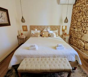 a bedroom with a large bed with a stone wall at La Maison du Clocher in Saint-Émilion