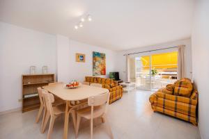 a living room with a table and chairs and a couch at Marbi in Cala Millor