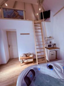 a room with a bath tub in the middle of a room at La Mezzanine - Chambre avec Spa in Bellaing