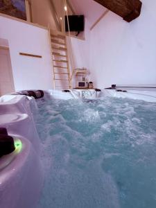 a large pool of water in a room at La Mezzanine - Chambre avec Spa in Bellaing