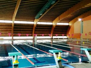 a large swimming pool with blue water and yellow cones at Apartamento Playa de Ris in Noja