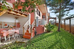 a patio with a table and chairs and a house at Casa Petite Paradise in La Laguna