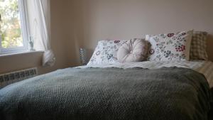 MartonにあるBright, Stylish 1 KS Bed Bungalow with Private Gardenの枕付きのベッドと窓のある寝室