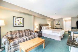 a hotel room with a bed and a couch at The Valley Inn, an Ascend Collection Hotel in Waterville Valley +41 photos