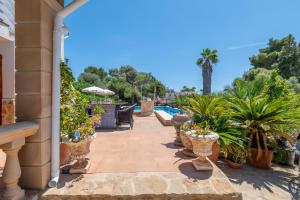 カラ・ムラダにあるVilla Juana Mariaの鉢植えの植物が植えられたパティオ、スイミングプール