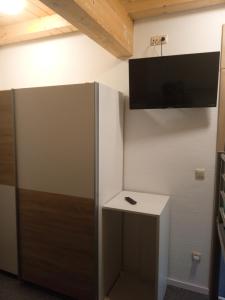 a room with a refrigerator and a tv on the wall at Großzügige Wohnung Bachblick in Wald