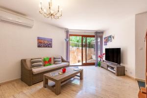 un salon avec un canapé et une télévision dans l'établissement Jolie Maison Proche Plage, à Toulon