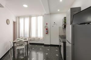 eine Küche mit Tisch und Kühlschrank in der Unterkunft Domus Superba - Genova in Genua
