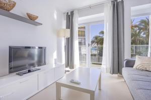 a white living room with a tv and a couch at Playa de Poniente 1-5 in Benidorm