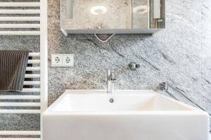 a white sink in a bathroom next to a staircase at See Oase in Uhldingen-Mühlhofen +18 photos