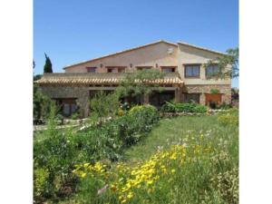 Una casa grande con un jardín enfrente. en Casa de vacaciones Mas del Pi, en Perelló