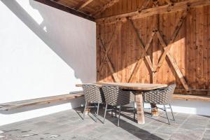 a table and chairs in a room with a wooden wall at La Grambla App Mont Seuc in Santa Cristina in Val Gardena