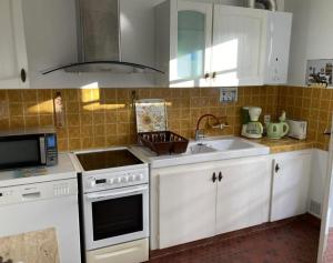 a kitchen with a sink and a stove top oven at Piraillan Foret - Réf 2064 in Lège-Cap-Ferret +10 photos