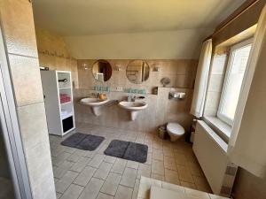 une salle de bain avec deux lavabos et deux miroirs dans l'établissement Ferienwohnungen Altes Land I Jork-Borstel, à Jork 17 autres photos