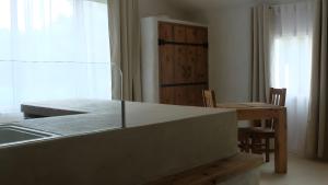 een keuken met een aanrecht, een tafel en een raam bij Gîte Le Chant Des Oiseaux in Sahorre